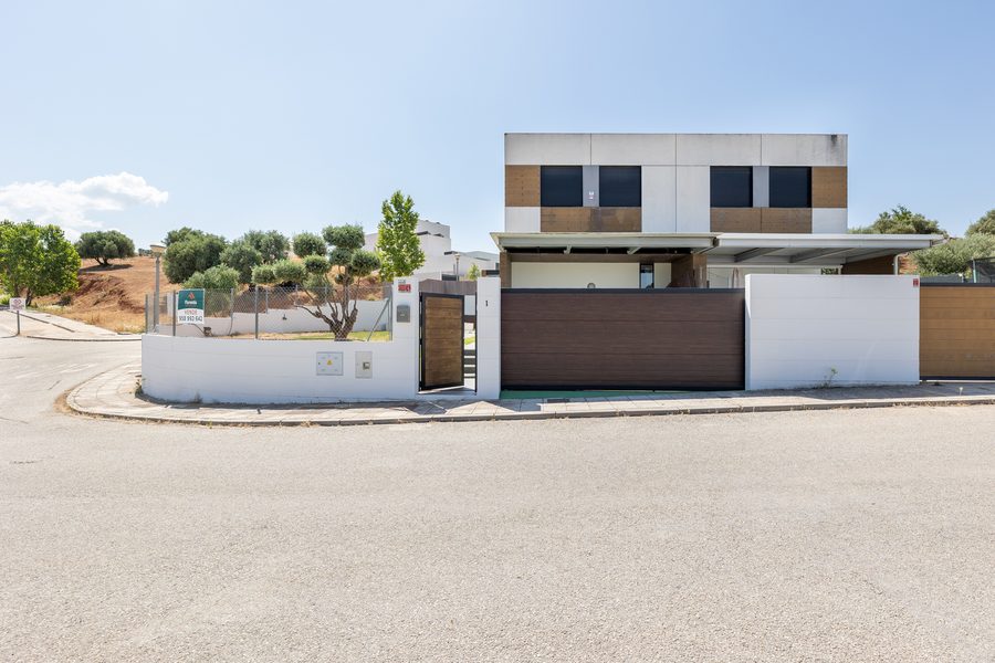 Vivienda moderna de dos plantas con cierre de madera en el Cortijo del Aire, con el cartel de venta de Florentia